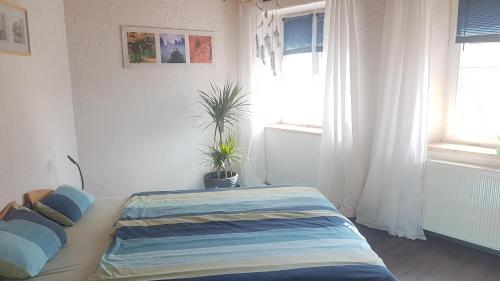 a bedroom with a bed with two potted plants on it at Ferienhaus Glücksnest in Hetzerath