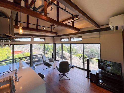 a living room with a large group of windows at UMI-IRO Onomichi Senkoji Park in Onomichi
