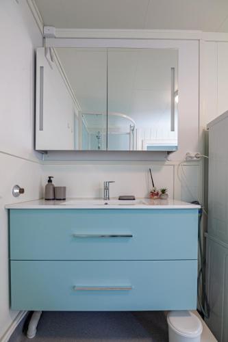 a bathroom with a blue sink and a mirror at Apartment in Stamsund in Stamsund