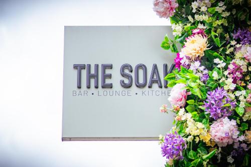 a sign for the spa with flowers on a wall at The Clermont London, Victoria in London
