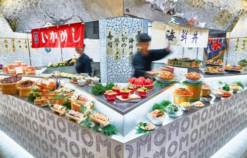 a food counter with two people preparing food at OMO5 Hakodate by Hoshino Resorts in Hakodate