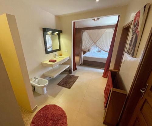 a bathroom with a sink and a bedroom with a bed at Agence Adjana Resort - Résidence du Port 3 in Sali Tapé