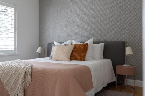 une chambre avec un grand lit avec des oreillers dans l'établissement Field Street Cottages - 2 Bedroom House - Centrally Located Luxury, à McLaren Vale