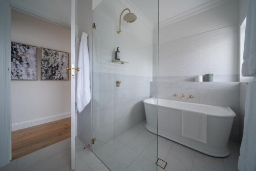a white bathroom with a sink and a shower at Field Street Cottages - 2 Bedroom House - Centrally Located Luxury in McLaren Vale