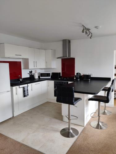 a kitchen with white cabinets and a black counter top at The Old Rope Works in Woburn Sands