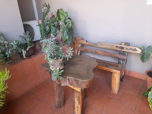 a wooden bench with potted plants on it at Boulevard Inn Mt Meru in Arusha