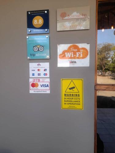 a door with some signs on a wall at Boulevard Inn Mt Meru in Arusha