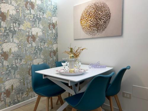 a dining room with a white table and blue chairs at La Chicca di Sofy in Orvieto