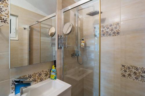 ein Badezimmer mit Dusche und Waschbecken in der Unterkunft Kuća za odmor R&A in Podstrana