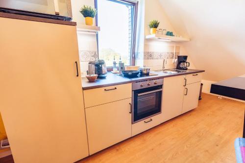 a kitchen with white appliances and a window at Romantik Studio - Cozy - Stylisch - Naturnah in Kempen