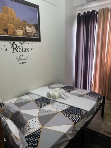 a bedroom with a bed with a quilt on it at PARANAQUE STAYCATION at SPRING RESIDENCES T3 U1231 in Manila