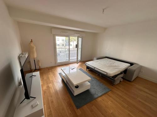 une pièce vide avec un lit et une table dans l'établissement Appartement neuf courbevoie Defense love A11, à Courbevoie