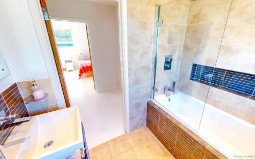 a bathroom with a shower and a tub at CROYDE MARRAM 5 Bedrooms in Croyde