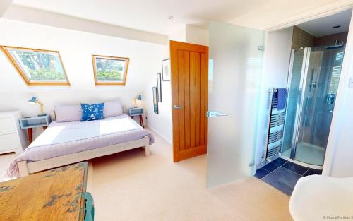 a bedroom with a bed and a sliding glass door at CROYDE MARRAM 5 Bedrooms in Croyde
