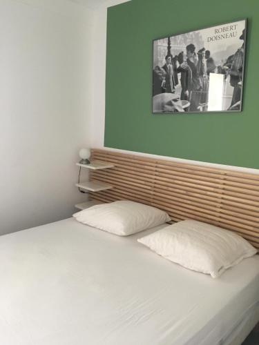 - un lit avec 2 oreillers et une photo au-dessus dans l'établissement Villa Heliovillage naturiste, au Cap d'Agde