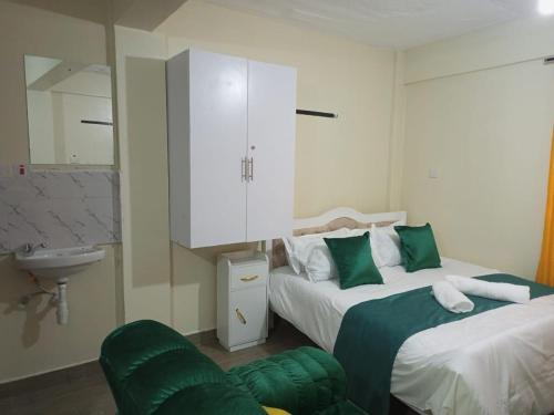 1 dormitorio con 2 camas y baño con lavamanos en Nanyuki homes en Nanyuki