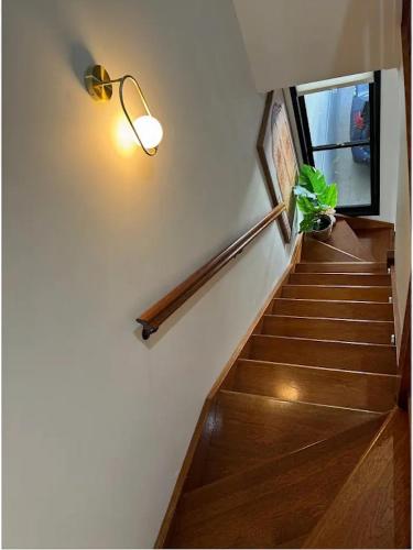 a staircase with a light and a plant on the wall at Stylish & Elegant 2BR Townhouse in Wilston, Brisbane in Brisbane