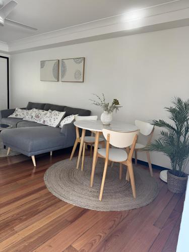 a living room with a table and a couch at Stylish & Elegant 2BR Townhouse in Wilston, Brisbane in Brisbane