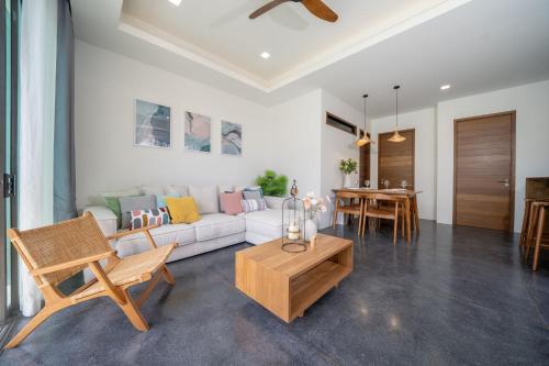 a living room with a white couch and a table at Stylish Pool Villa in Chalong-Phuket-2 Bedroom in Ban Suan