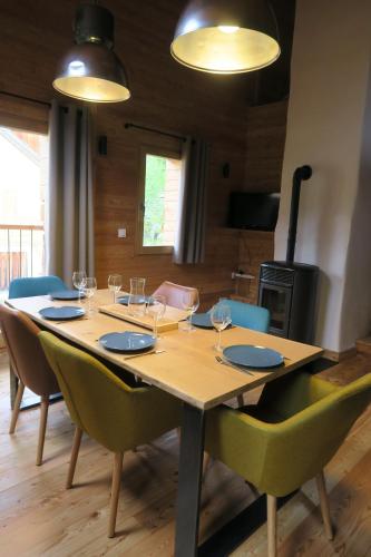 - une table en bois avec des chaises et des verres à vin dans l'établissement Le Grenier 1746, à Névache