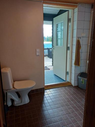 a bathroom with a toilet and an open door at Mertaranta in Pääjärvi