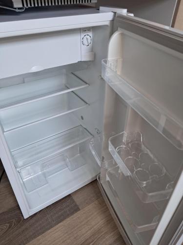 an empty refrigerator with its door open and a drawer at LAETITIA ET CLAUDE in Lille
