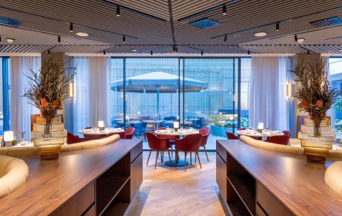 a restaurant with tables and chairs and large windows at Altis Porto Hotel in Porto