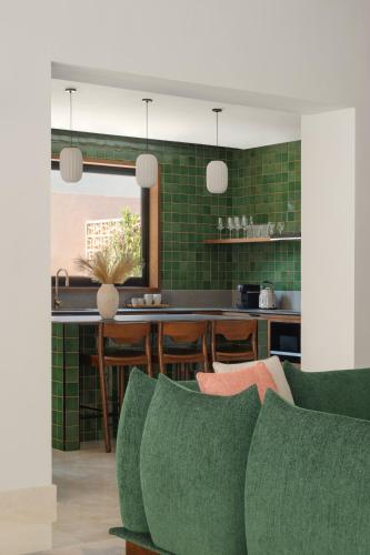 a kitchen with green tiled walls and a green couch at Meliá Desert Palm Member of Meliá Collection in Dubai