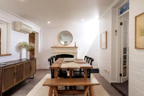 ein Esszimmer mit Tisch und Kamin in der Unterkunft Tamara Cottage Historic Warmth in Hobart