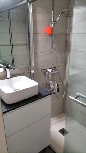 une salle de bain avec un lavabo et une douche dans l'établissement Villa Heliovillage naturiste, au Cap d'Agde