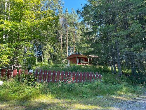 a house in the woods behind a fence at Villa vappu in Kuopio