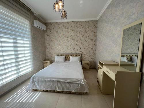 a small bedroom with a bed and a mirror at DMC House in Gabala