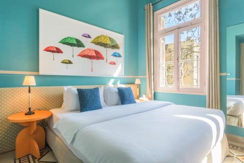 a bedroom with a large bed with blue walls and a window at SAYA La Villa in Mar Mikhael in Beirut