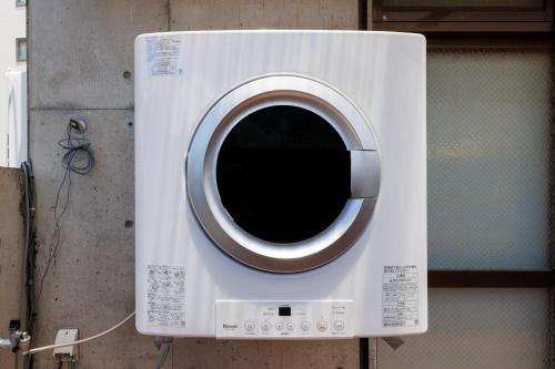 a washing machine with a window in a wall at 国際通り徒歩1分 駐車場2台 最大11名 空港車で10分 周辺には飲食店多数の那覇エリア さくらや国際通り in Naha
