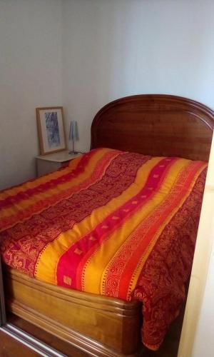 - un lit avec une couverture rouge et jaune dans l'établissement Appartement, à Seyne