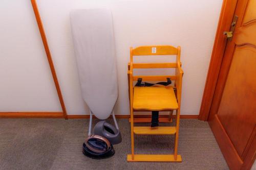 a kitchen with a whisk and a wooden chair and a refrigerator at 国際通り徒歩1分 駐車場2台 最大11名 空港車で10分 周辺には飲食店多数の那覇エリア さくらや国際通り in Naha