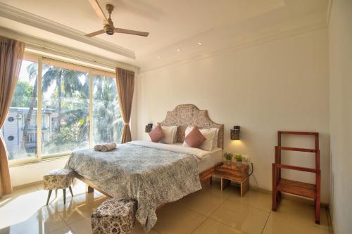 a bedroom with a bed and a large window at Hotel Sea Sapphire ,Calangute in Calangute