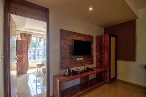 a living room with a television on a wall at Hotel Sea Sapphire ,Calangute in Calangute