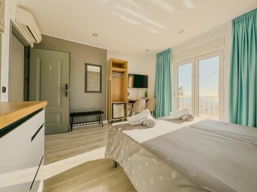 a bedroom with a bed with blue curtains and a kitchen at Villa Dru in Roquetas de Mar