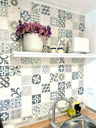 a kitchen with a sink and a tiled wall at A casa dos avós in Abrantes