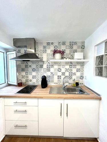 a kitchen with white cabinets and a sink at A casa dos avós in Abrantes