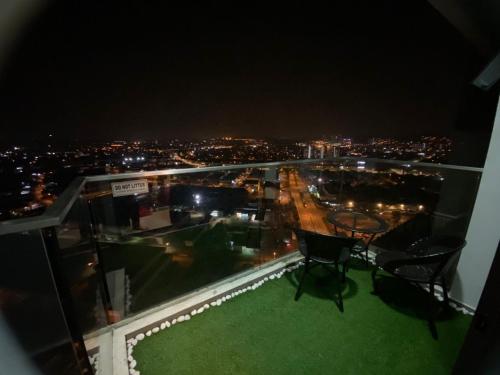 a balcony with a table and chairs on the roof at night at THE FAMILY HOMESTAY@UNIV360 PLACE,SERDANG in Seri Kembangan