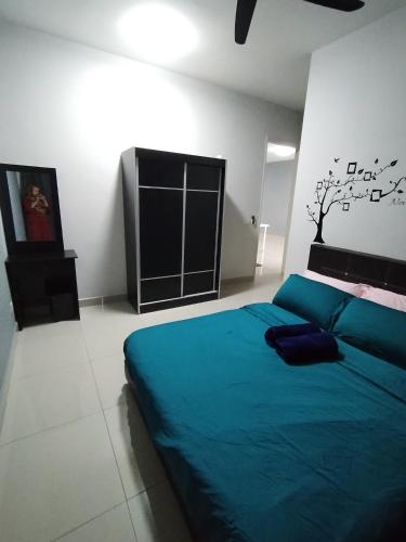 a bedroom with a blue bed and a tree on the wall at THE FAMILY HOMESTAY@UNIV360 PLACE,SERDANG in Seri Kembangan
