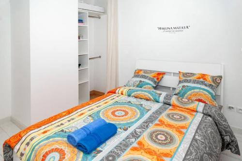 - une chambre avec un lit doté de draps et d'oreillers colorés dans l'établissement Joli appartement proche Disney !, à Montévrain