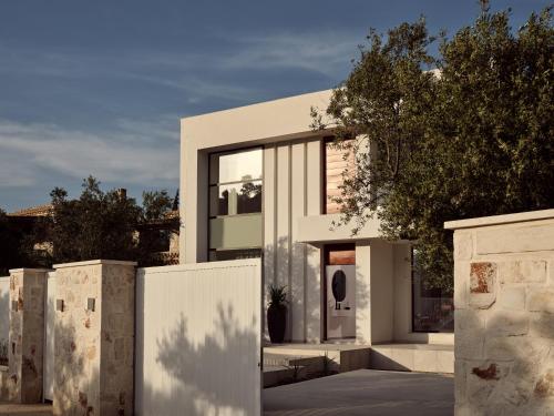 a white house with a fence in front of it at The White Luxury Villa - Private Seaview Villa with Pool by Villa Mana Gers in Vasilikos