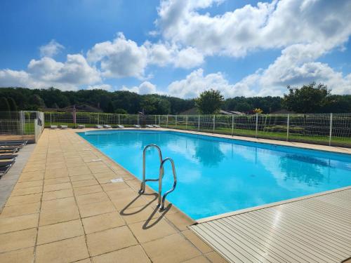 une grande piscine avec de l'eau bleue dans l'établissement French Country Villas, à Les Forges