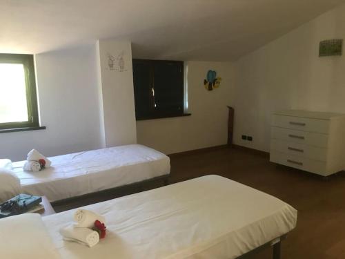 a hotel room with two beds and a dresser at La casa langhetta in Albaretto Della Torre 