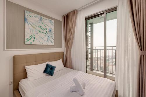 a bedroom with a bed and a window with a view at Smile Home Tresor apartment - Modern comfortable in Ho Chi Minh City
