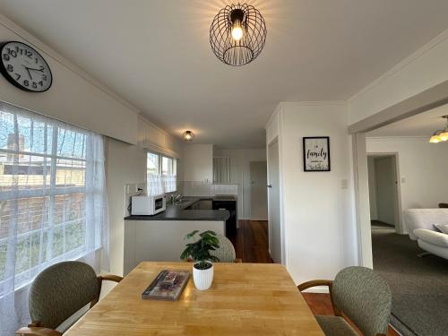 a kitchen and dining room with a table and a clock at Gracious 3 Bdrm House in Chartwell in Hamilton
