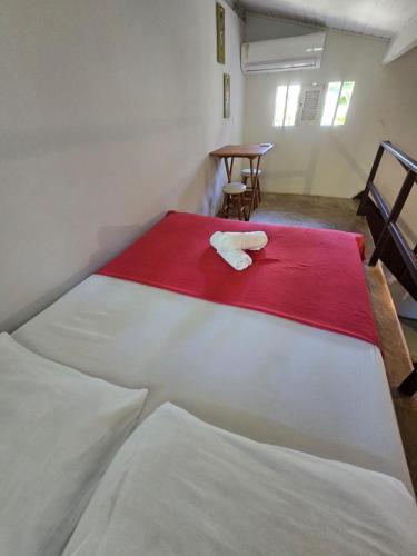 two beds in a room with a red and white blanket at Stay Cool Pipa in Pipa